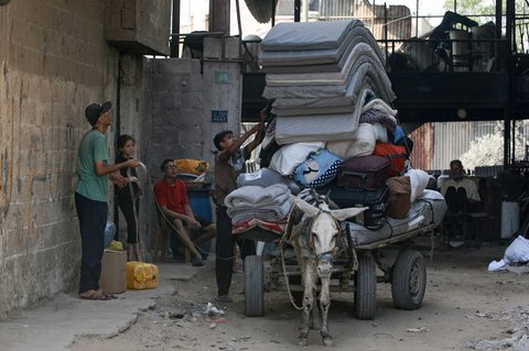 Warga Palestina memuat barang-barang mereka ke gerobak yang ditarik keledai saat bersiap  mengungsi  dari permukiman Abu Iskandar di utara Kota Gaza, Palestina, Jumat (22/08/2025). .
