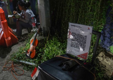 Pengamen Kris Violist dan istrinya di perempatan Juanda, Depok, Jumat malam (22/08/2025).