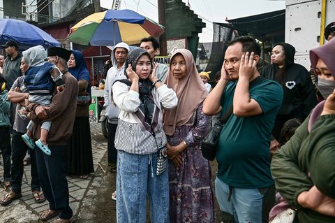 Warga menutup telinga saat kegiatan sound horeg menyambut perayaan Hari Kemerdekaan Indonesia ke-80 di Malang, Jawa Timur (09/08/2025).