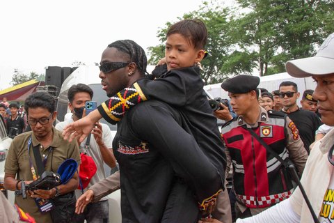 Penari pacu jalur Rayyan Arkan Dikha digendong rapper Amerika Melly Mik  saat mereka meninggalkan festival Pacu Jalur di Sungai Kuantan, di Kabupaten Kuantan Singingi, Provinsi Riau, Minggu (24/08/2025).