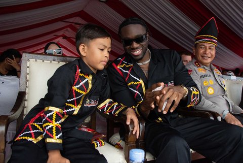 Penari pacu jalur Rayyan Arkan Dikha berbincang dengan rapper Amerika Melly Mike disaksikan Kapolda Riau Irjen Herry Heryawan saat festival Pacu Jalur di Sungai Kuantan, di Kabupaten Kuantan Singingi, Provinsi Riau, Minggu (24/08/2025).