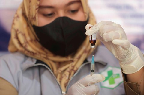 Petugas kesehatan mempersiapkan  suntikan vaksin campak kepada seorang anak dalam kampanye vaksinasi campak setelah wabah di Sumenep, Jawa Timur, Indonesia, Indonesia, Senin (25/08/2025).