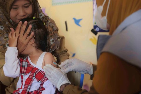 Petugas kesehatan memberikan suntikan vaksin campak kepada seorang anak dalam kampanye vaksinasi campak setelah wabah di Sumenep, Jawa Timur, Indonesia, Indonesia, Senin (25/08/2025).