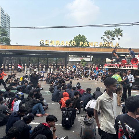 Berbaju Hitam Duduk di Tengah Jalan massa pendemo Gedung DPR