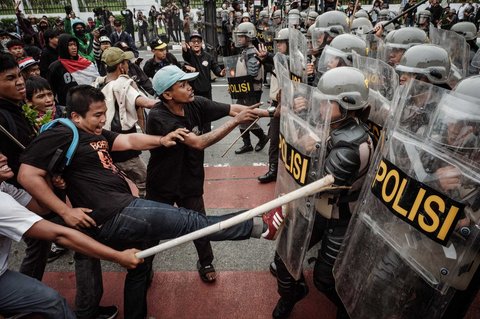 Pengunjuk rasa menendang ke arah barikade petugas kepolisian saat demo menuntut pembubaran DPR di depan Gedung DPR/ MPR, Jakarta, Senin (25/08/2025).
