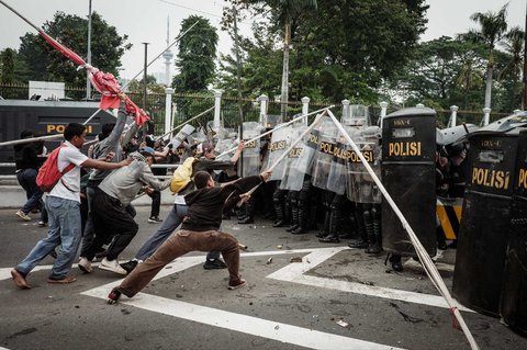 Pengunjuk rasa memukul barikade petugas kepolisian saat demo menuntut pembubaran DPR di depan Gedung DPR/ MPR, Jakarta, Senin (25/08/2025).
