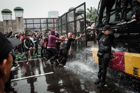 Pengunjuk rasa mendobrak barikade petugas kepolisian saat demo menuntut pembubaran DPR di depan Gedung DPR/ MPR, Jakarta, Senin (25/08/2025).