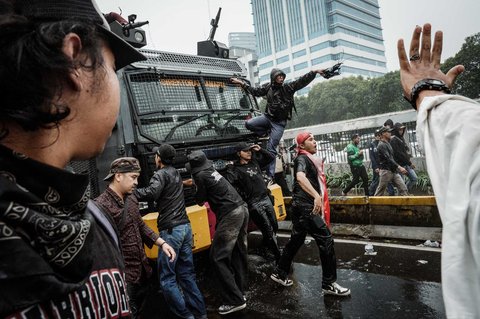 Pengunjuk rasa menahan laju mobil water canon saat demo menuntut pembubaran DPR di depan Gedung DPR/ MPR, Jakarta, Senin (25/08/2025).