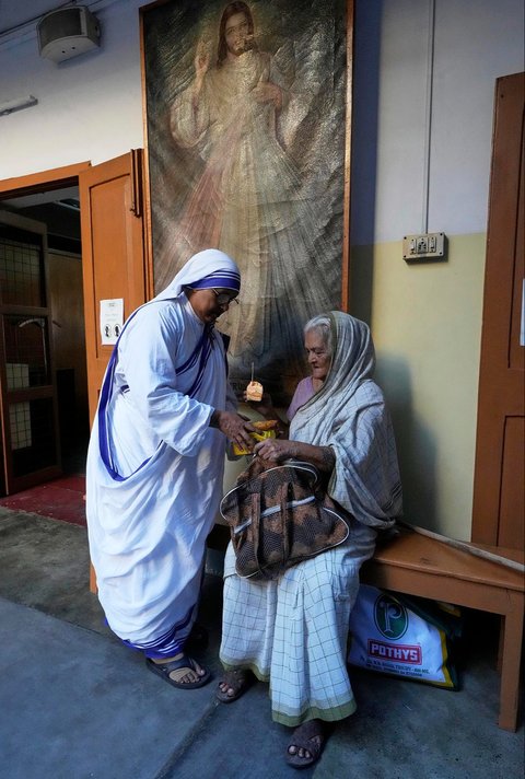 Biarawati dari Misionaris Cinta Kasih membagikan makanan kepada seorang lanjut usia di dekat makam Santa Teresa, pada peringatan hari kelahirannya di Kolkata, India, Selasa, (26/08/2025).<br />AP/Bikas Das