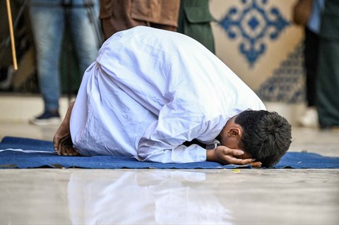 Seorang pria  menangis saat menjalani hukuman cambuk di depan umum oleh anggota polisi syariat di Banda Aceh, Selasa (26/08/2025).