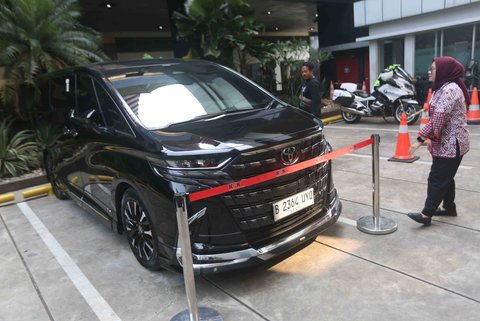 Petugas Komisi Pemberantasan Korupsi (KPK)  beridiri di samping mobil Alphard hasil sitaan penggeledahan rumah dinas eks Wakil Menteri Ketenagakerjaan (Wamenaker) Immanuel Ebenezer di kawasan Pancoran, Jakarta Selatan, Selasa (26/08/2025).