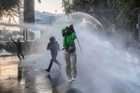 Polisi menyemprotkan water canon ke arah pengunjuk rasa saat  aksi protes menyoroti kebijakan kenaikan tunjangan anggota DPR di depan kantor DPRD Sumatera Utara (Sumut) Jalan Imam Bonjol, Medan, Selasa , (26/08/2025).