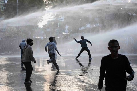 Pengunjuk rasa melemparkan batu ke arah polisi anti huru hara saat  aksi protes menyoroti kebijakan kenaikan tunjangan anggota  DPR di depan kantor DPRD Sumatera Utara (Sumut) Jalan Imam Bonjol, Medan, Selasa , (26/08/2025).