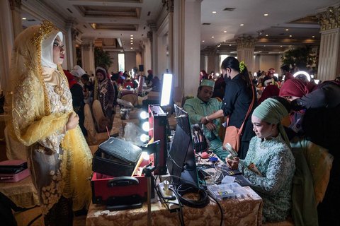 Para calon pengantin merias wajah mereka saat mempersiapkan acara Isbat nikah massal 2025 yang diselenggarakan Pemerintah Kota Surabaya di Grand Empire Palace Hotel Surabaya, Rabu (27/8/2025).