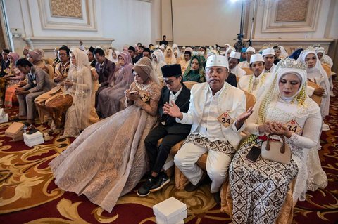 Pasangan pengantin berfoto usai mengikuti Isbat nikah massal 2025 yang diselenggarakan Pemerintah Kota Surabaya di Grand Empire Palace Hotel Surabaya, Rabu (27/8/2025).