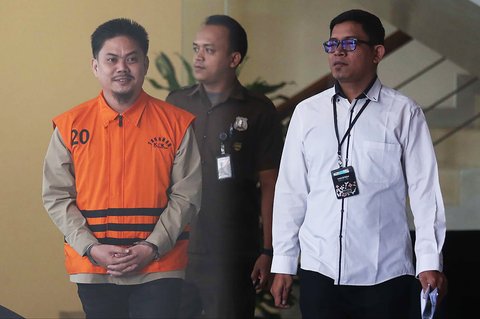 Bupati nonaktif Kolaka Timur Abdul Aziz dengan memakai rompi KPK dan tangan diborgol berjalan keluar usai menjalani pemeriksaan di Gedung Merah Putih Komisi Pemberantasan Korupsi, Jakarta, Rabu (27/8/2025). <br />Liputan6.com/Helmi Fithriansyah