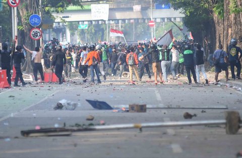 Massa melempar batu ke arah pasukan Brimob di Mako Brimob, Kwitang, jakarta, Jumat (29/08/2025).