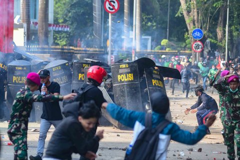 Massa melempar batu ke arah pasukan Brimob di Mako Brimob, Kwitang, jakarta, Jumat (29/08/2025).
