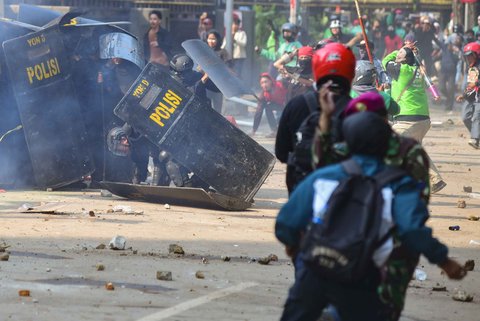 Massa melempar batu ke arah pasukan Brimob di Mako Brimob, Kwitang, jakarta, Jumat (29/08/2025).