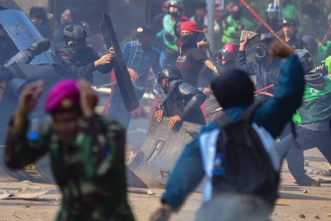 Massa melempar batu ke arah pasukan Brimob di Mako Brimob, Kwitang, jakarta, Jumat (29/08/2025).