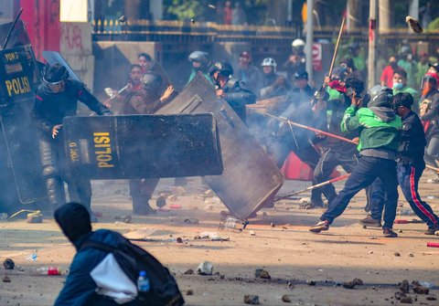 Massa melempar batu ke arah pasukan Brimob di Mako Brimob, Kwitang, jakarta, Jumat (29/08/2025).