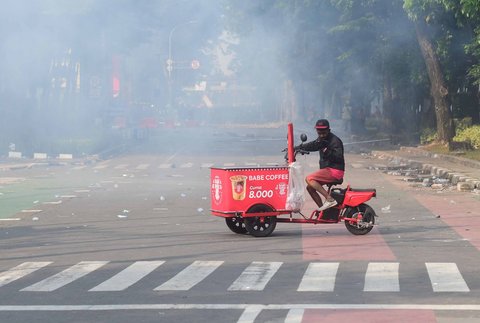 Penjual kopinkeliling terjebak diantara gas air mata di depan Mako Brimob, Kwitang, jakarta, Jumat (29/08/2025).