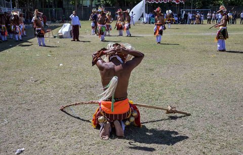 Para pria Manggarai bersiap sebelum mengikuti Caci yaitu ritual adu cambuk  di Stadion Galing Surabaya, Minggu (03/08/2025