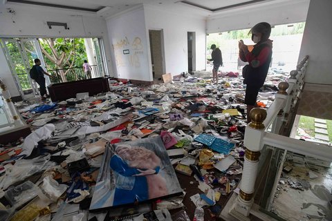 Sejumlah warga menyaksikan  rumah Anggota DPR Surya Utama atau Uya Kuya yang berantakan  setelah dirusak massa tak dikenal di Pondok Bambu, Jakarta Timur, Minggu (31/8/2025).