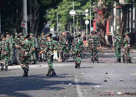 Personel TNI gabungan Kostrad dan Marinir membersihkan material sisa unjuk rasa di kawasan Mako Brimob, Kwitang, Senen, Jakarta, Minggu (31/8/2025).