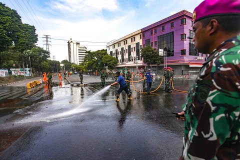 Personel TNI gabungan Kostrad dan Marinir membersihkan material sisa unjuk rasa di kawasan Mako Brimob, Kwitang, Senen, Jakarta, Minggu (31/8/2025).