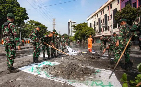 Personel TNI gabungan Kostrad dan Marinir membersihkan material sisa unjuk rasa di kawasan Mako Brimob, Kwitang, Senen, Jakarta, Minggu (31/8/2025).