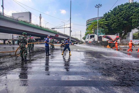 Personel TNI gabungan Kostrad dan Marinir membersihkan material sisa unjuk rasa di kawasan Mako Brimob, Kwitang, Senen, Jakarta, Minggu (31/8/2025).