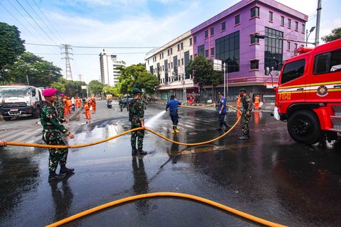 Personel TNI gabungan Kostrad dan Marinir membersihkan material sisa unjuk rasa di kawasan Mako Brimob, Kwitang, Senen, Jakarta, Minggu (31/8/2025).