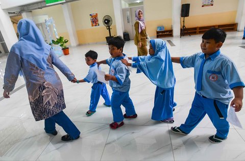 Murid sekolah dasar berbaris sebelum  kegiatan Cek Kesehatan Gratis (CKG) di SD Prestasi Global, Depok, Jawa Barat, Senin (04/08/2025).