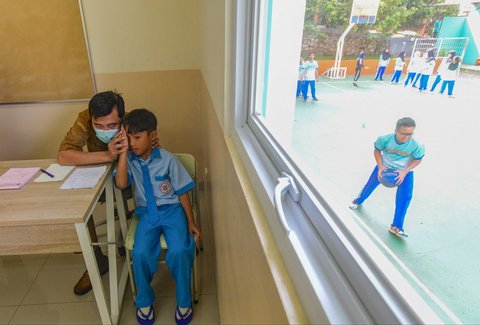 Murid sekolah dasar dicek kesehatan matanya saat kegiatan Cek Kesehatan Gratis (CKG) di SD Prestasi Global, Depok, Jawa Barat, Senin (04/08/2025).