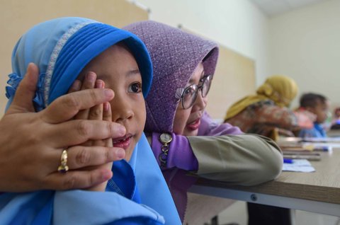 Murid sekolah dasar dicek kesehatan matanya saat kegiatan Cek Kesehatan Gratis (CKG) di SD Prestasi Global, Depok, Jawa Barat, Senin (04/08/2025).