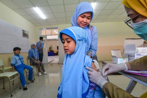 Murid sekolah dasar mendapatkan imunisasi vaksin rubella MR saat kegiatan Cek Kesehatan Gratis (CKG) di SD Prestasi Global, Depok, Jawa Barat, Senin (04/08/2025).