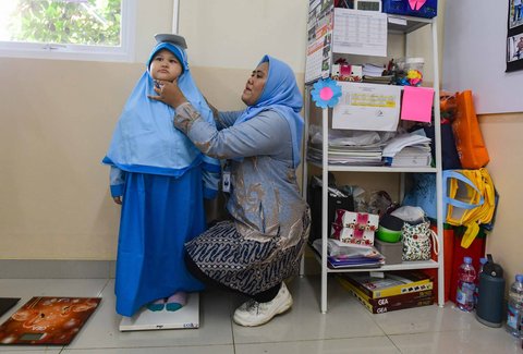 Murid sekolah dasar dicek tinggi badan saat kegiatan Cek Kesehatan Gratis (CKG) di SD Prestasi Global, Depok, Jawa Barat, Senin (04/08/2025).