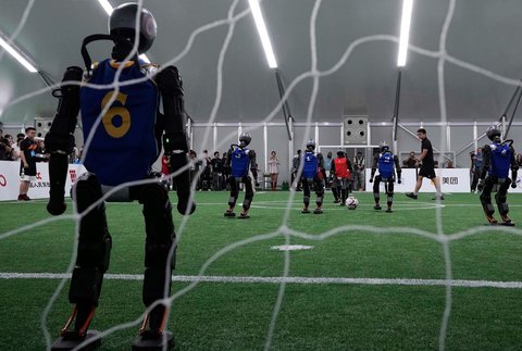 Robot humanoid saat bermain sepak bola dalam pertandingan eksibisi menjelang World Humanoid Robot Games 2025 yang dijadwalkan mulai 14 hingga 17 Agustus di Beijing, Tiongkok, Senin (04/08/2025).