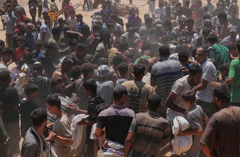 Warga Palestina berebut  mengambil bantuan kemanusiaan yang dijatuhkan dengan parasut ke Zawaida di Jalur Gaza tengah, Senin (04/08/2025).