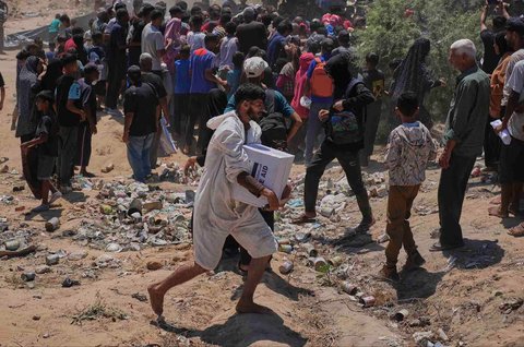 Warga Palestina berebut  mengambil bantuan kemanusiaan yang dijatuhkan dengan parasut ke Zawaida di Jalur Gaza tengah, Senin (04/08/2025).