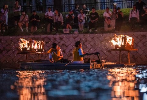 Warga menyalakan unggun di sepanjang Sungai Motoyasu di depan Kubah Bom Atom saat peringatan 80 tahun serangan bom atom pertama di kota Hiroshima, Jepang, Selasa (05/08/2025).