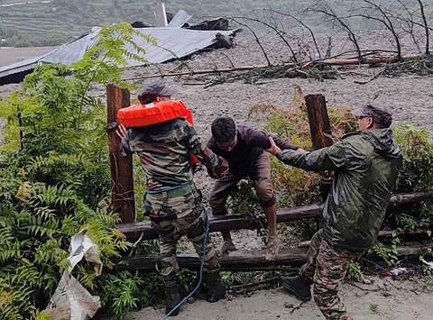 Anggota militer AD India  menyelamatkan seorang penduduk setempat dari timbunan longsor di negara bagian Uttarakhand, India, Selasa (05/08/2025).