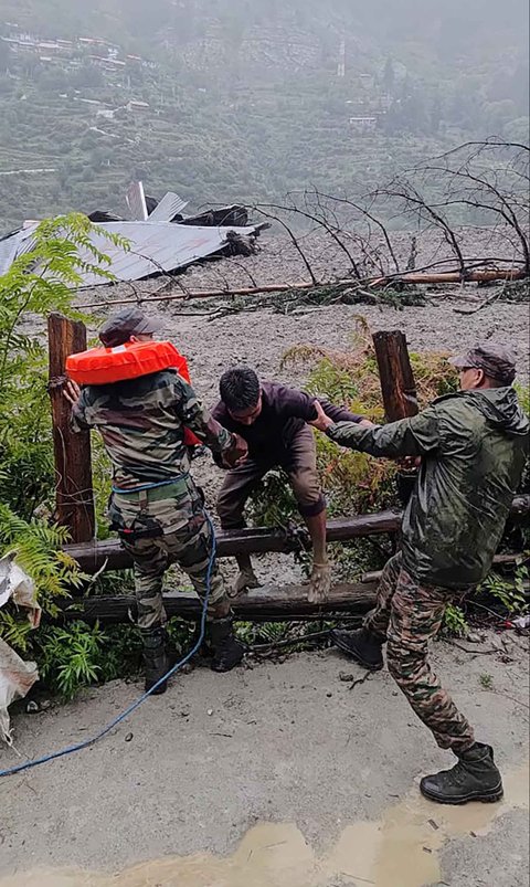 Anggota militer AD India  menyelamatkan seorang penduduk setempat dari timbunan longsor di negara bagian Uttarakhand, India, Selasa (05/08/2025).
