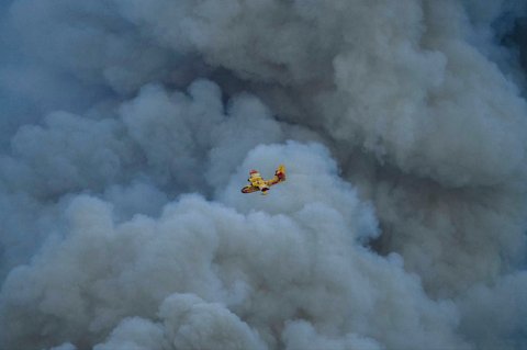 Pesawat Canadair CL-415 milik keamanan sipil Prancis terbang di atas kebakaran hutan di Jonqui&egrave;res, Prancis barat daya, Selasa (05/08/2025) waktu setempat.