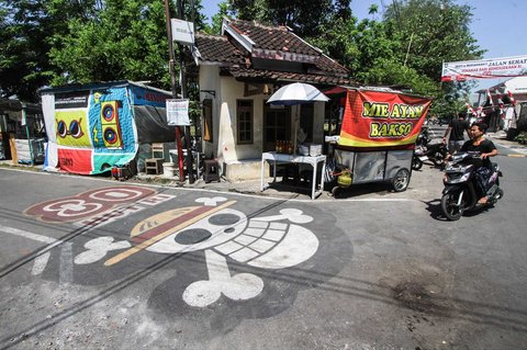 Grafiti bendera bajak laut dari anime Jepang One Piece terlihat di sebuah jalan di Sukoharjo, Jawa Tengah, Rabu (06/08/2025).