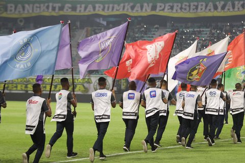 Volunteer membawa bendera klub peserta Liga 1 saat pembukaan BRI Super League 2025/2026 di Stadion Gelora Bung Tomo, Surabaya, Jawa Timur, Jumat (8/8/2025)