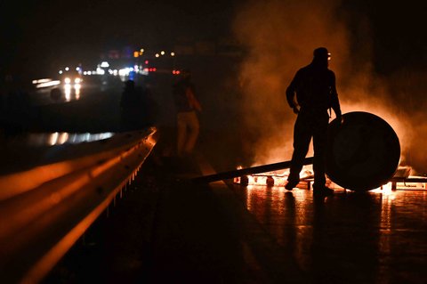 Para demonstran melakukan aksi pembakaran untuk memblokir jembatan Viaduc de Calix dalam aksi gerakan nasional "Mari Kita Blokir Semuanya&rdquo; di Caen, Prancis barat laut, Selasa (10/09/2025).