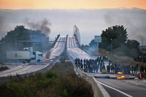 Para demonstran melakukan aksi pembakaran untuk memblokir jembatan Viaduc de Calix dalam aksi gerakan nasional "Mari Kita Blokir Semuanya&rdquo; di Caen, Prancis barat laut, Selasa (10/09/2025).