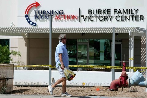 Seorang simpatisan berjalan untuk meletakkan karangan bunga setelah penembakan yang menewaskan Charlie Kirk di kantor pusat Turning Point USA di Phoenix,  Amerikas Serikat, Rabu (10/09/2025).